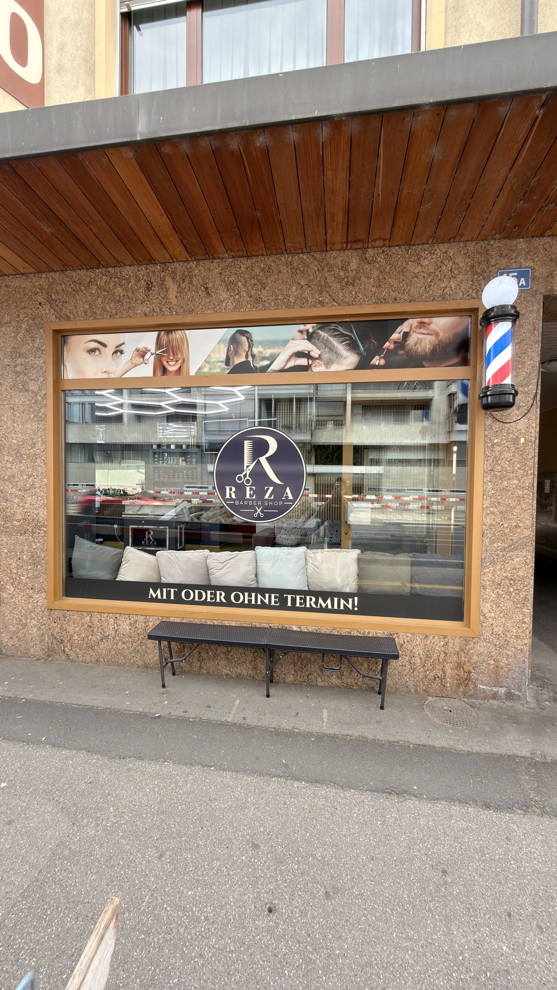 Schaufenster von Reza Barber Shop mit Logo, Barber-Säule und dem Hinweis «Mit oder ohne Termin!»